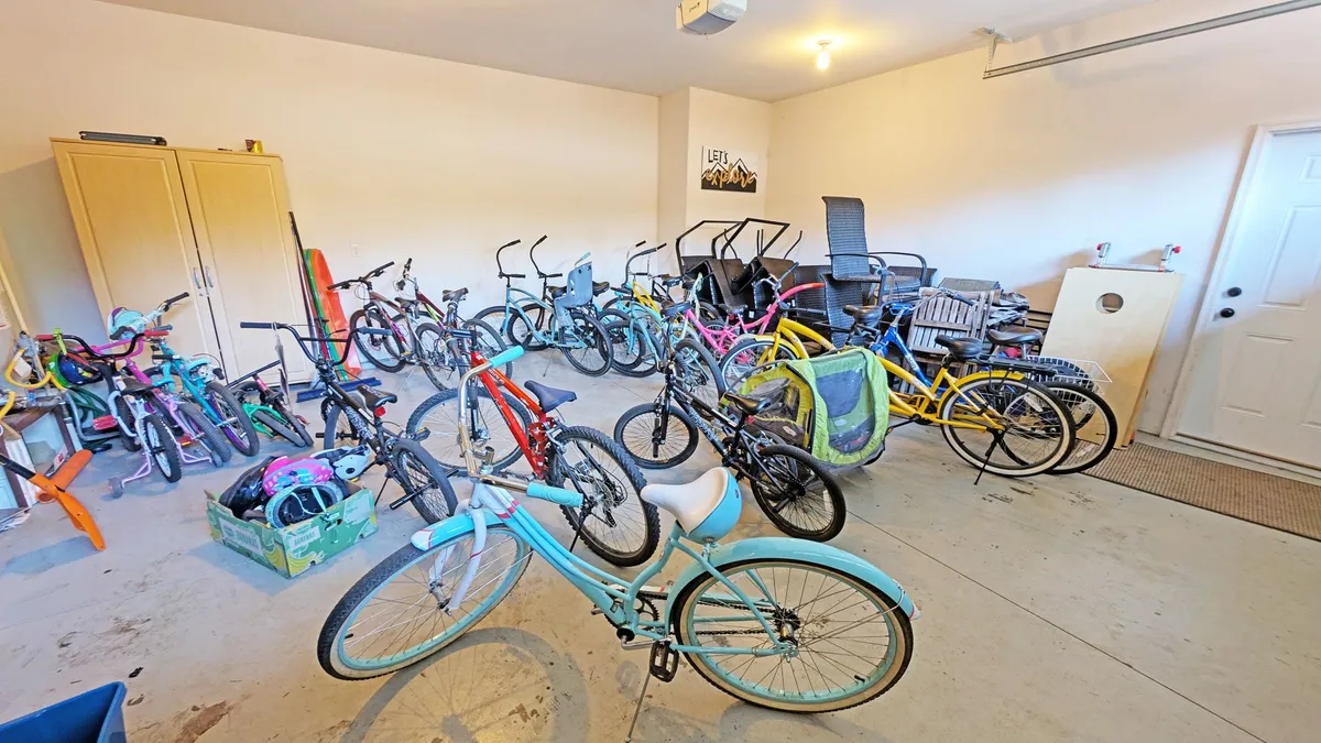 A well-organized garage space featuring a variety of bicycles and storage cabinets, with exercise equipment visible. The setting suggests readiness for group outdoor adventures and easy access for hitting the trails.